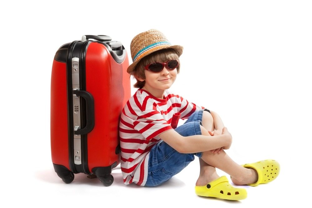 Children sitting next to their suitcase before a trip - Kids-ID