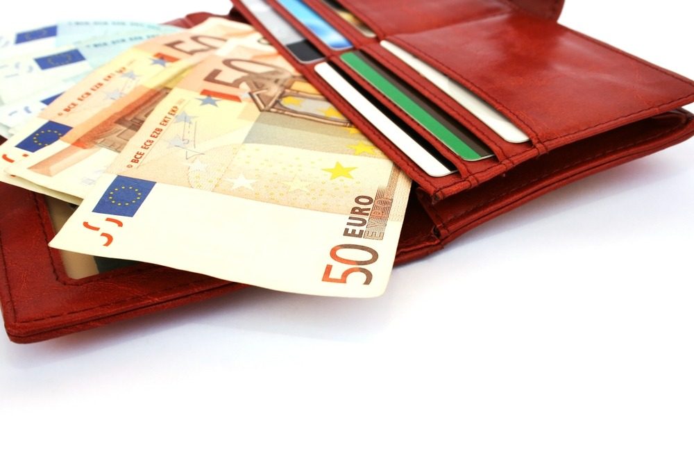 red wallet containing credit cards and euro cash