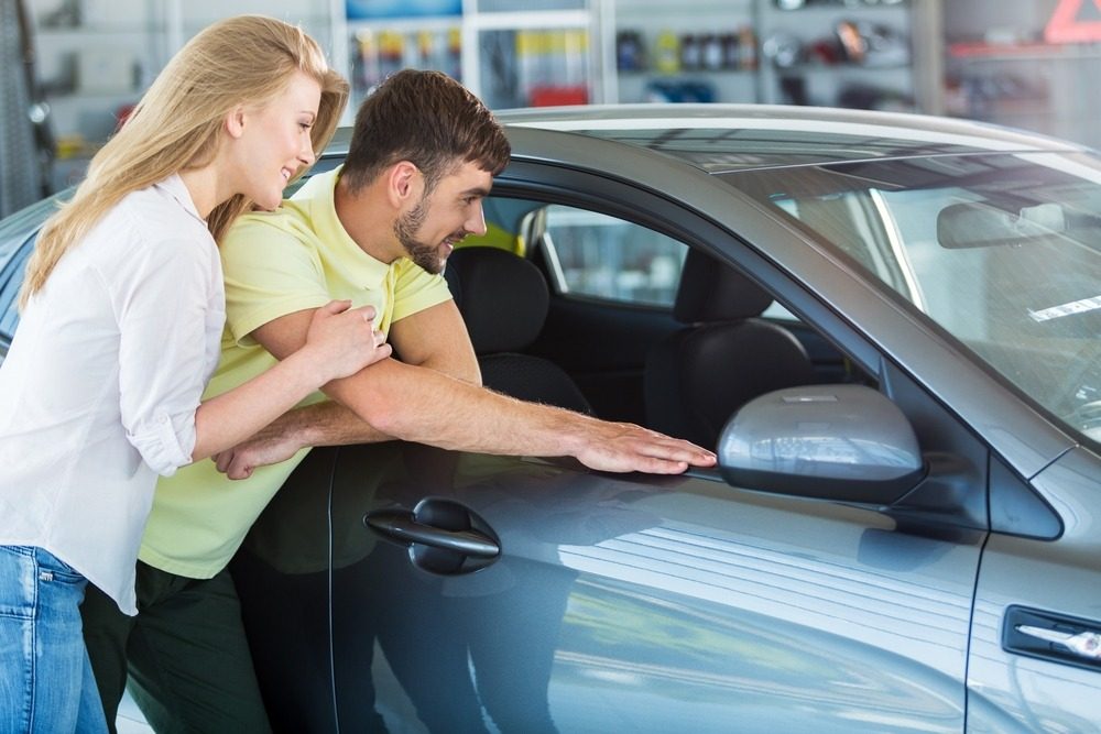 Koppel bekijkt auto un een autoverkoopcentrale