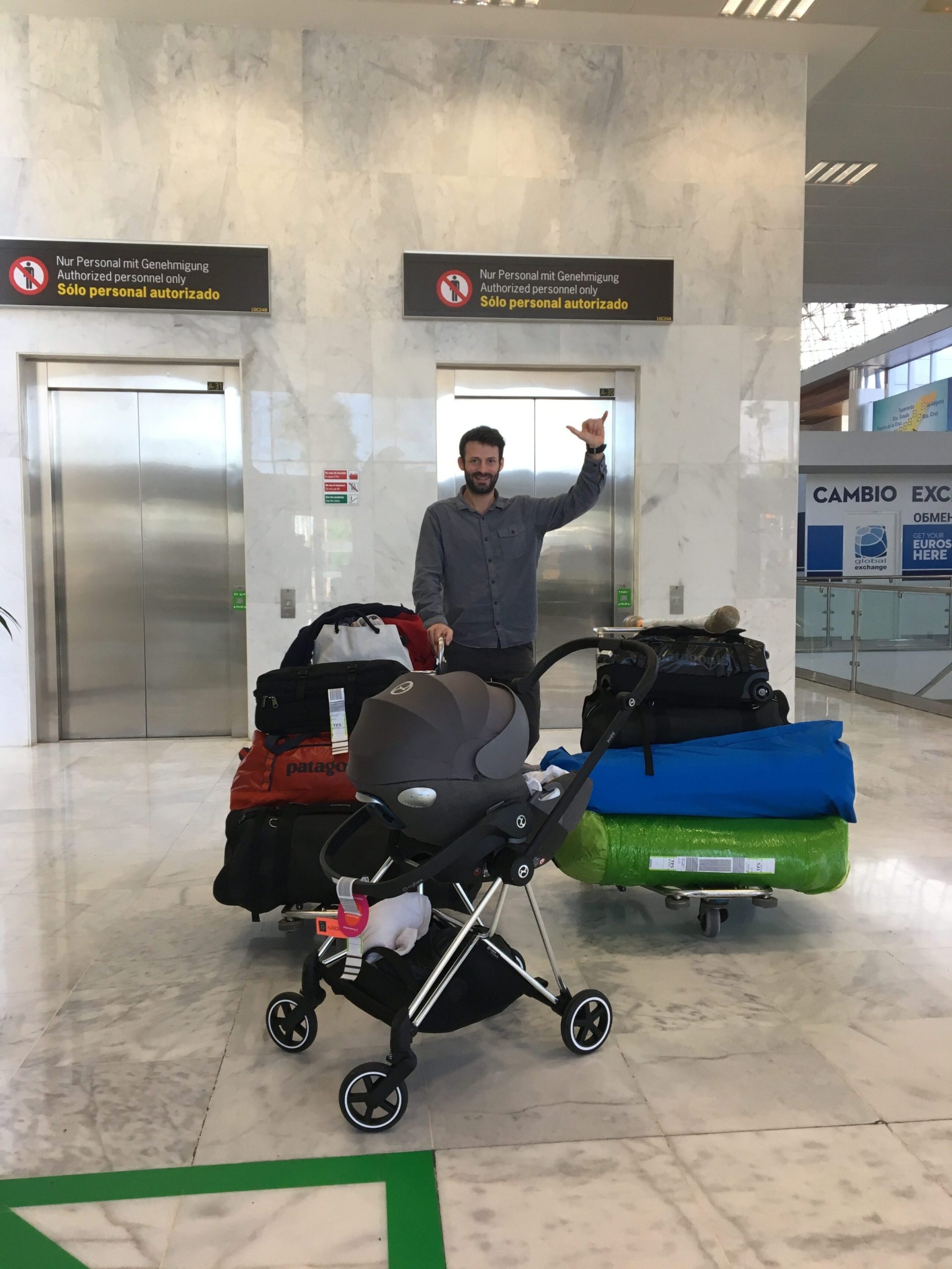 Tom de Dorlodot with his baby in a car seat in front of an airport lift