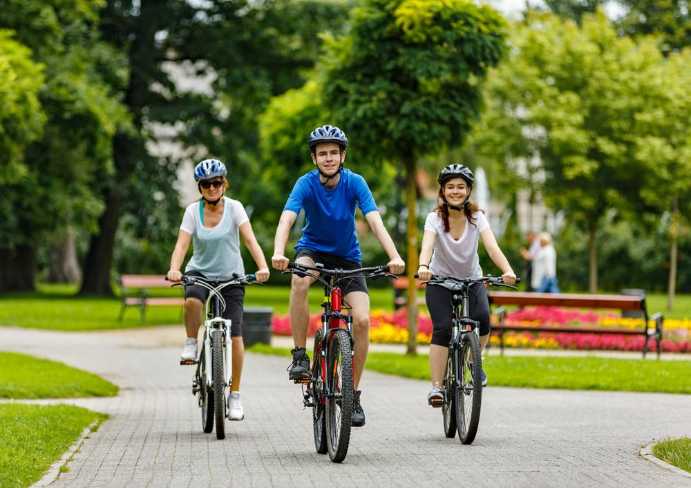 Trois jeunes cyclistes dans un parc