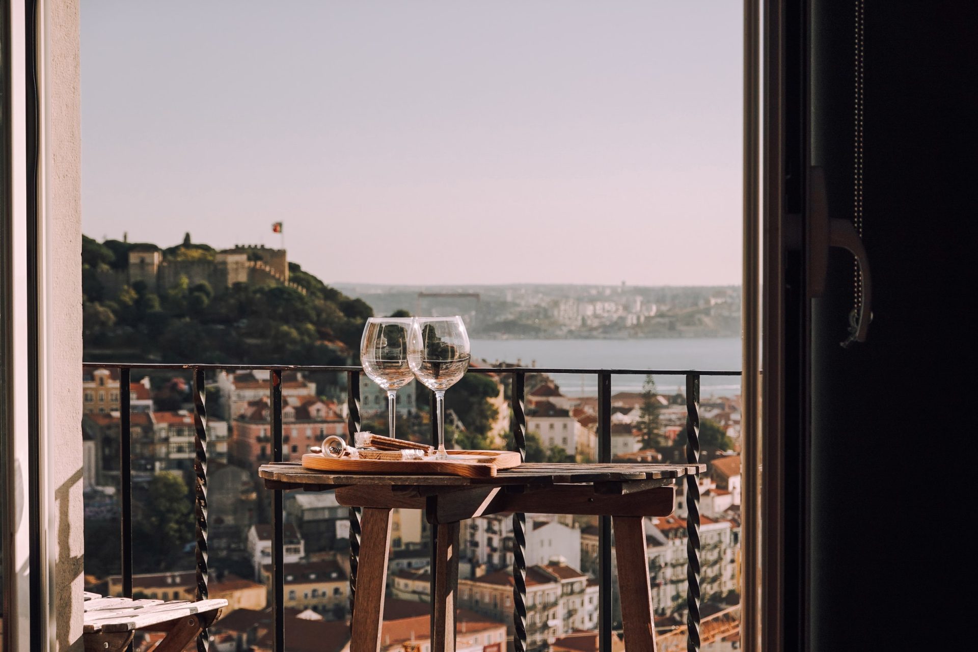 tafel met twee gevulde wijglazen op balkon van vakantiewoning