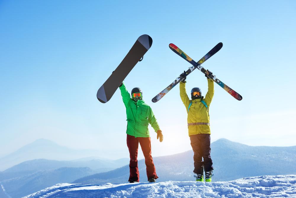 Personnes sur une montagne montrant des skis et un snowboard