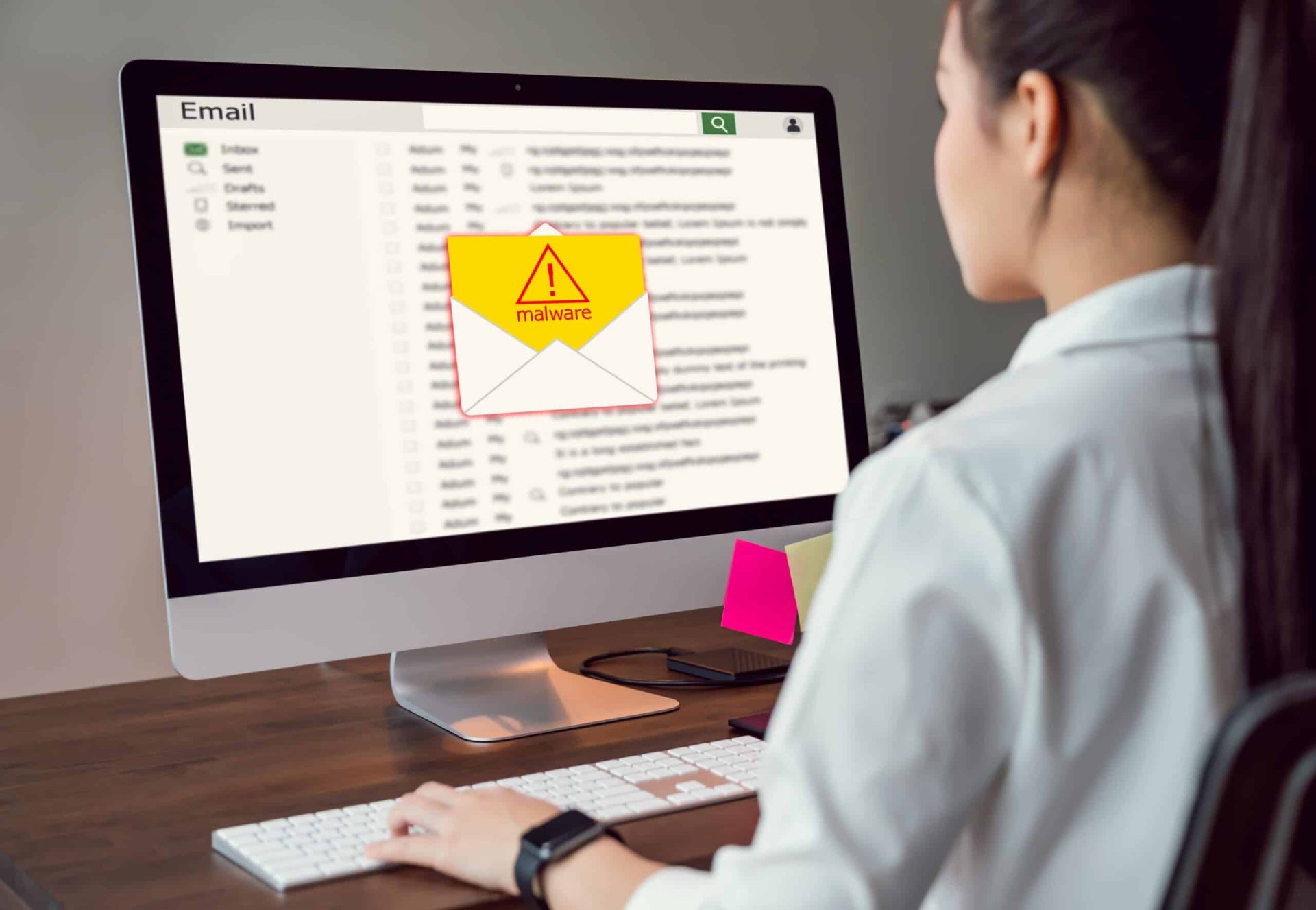 person sitting in front of their computer displaying a danger message