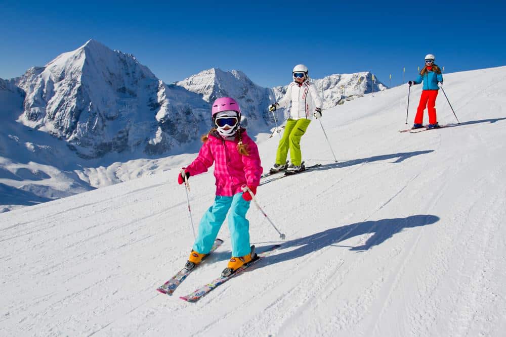 Couple and child skiing down the slope in the mountains