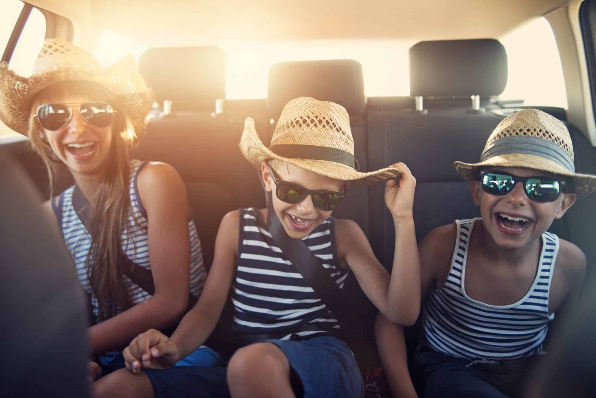 Children in the back seats of a car on the way to their holiday