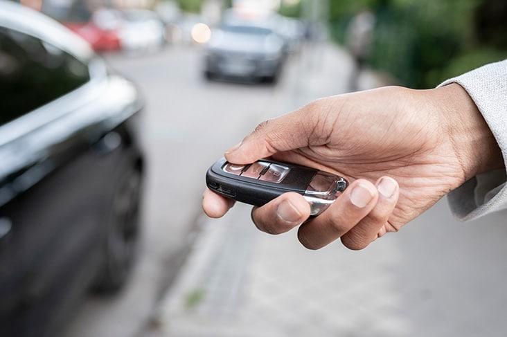 Man opent zijn auto met zijn digitale autosleutel